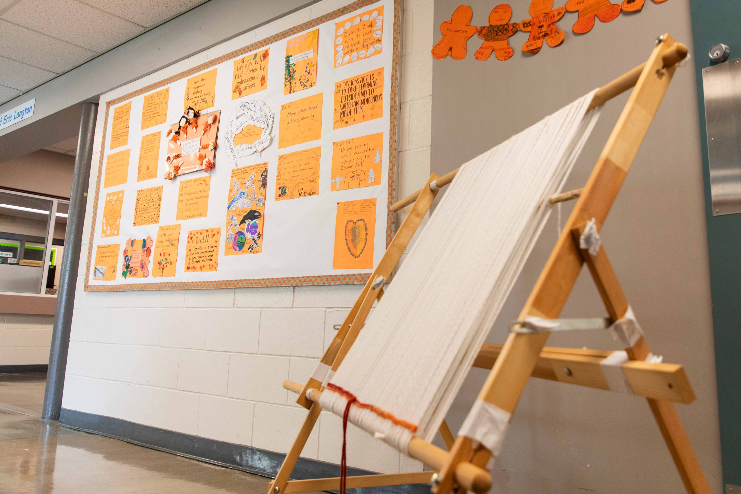 A loom next to a bulletin board outlining acts of reconciliation that classes at Eric Langton Elementary have committed to.