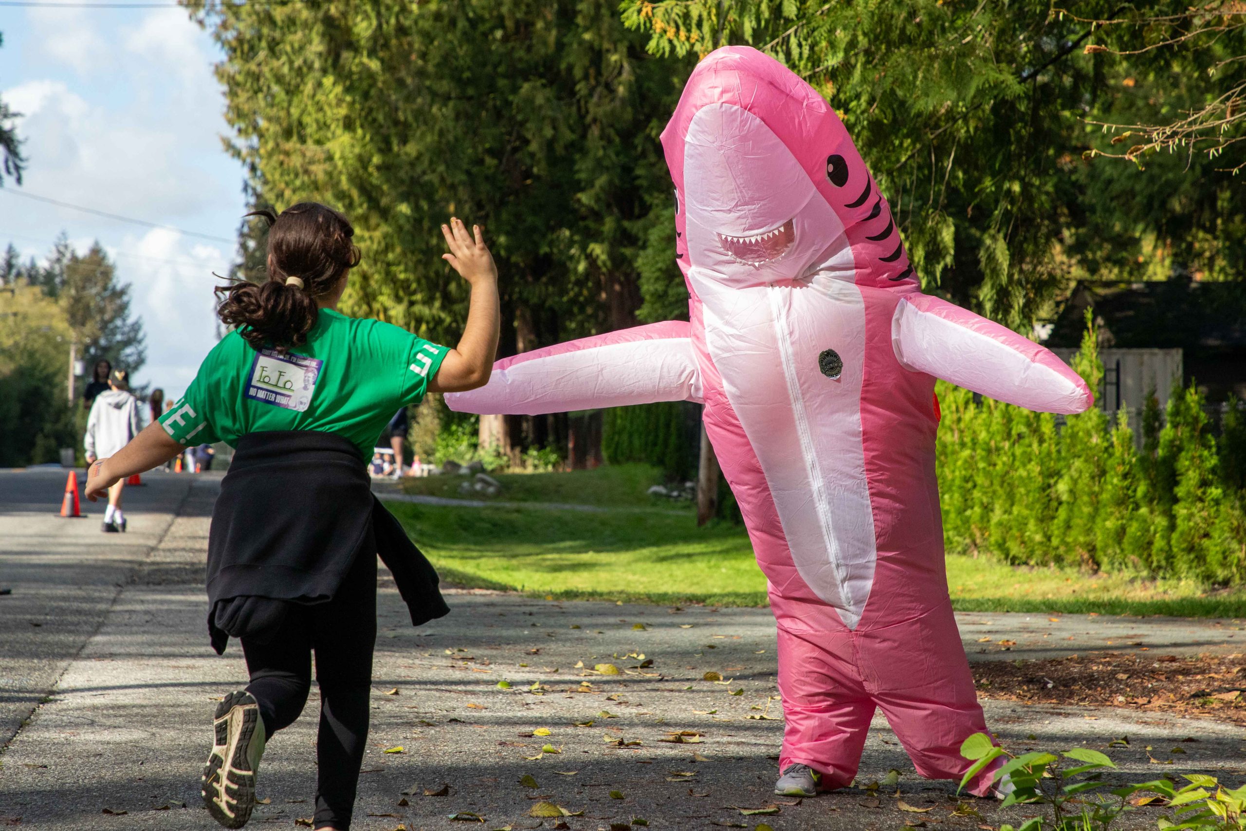 Yennadon Elementary student high fives RCMP officer dressed as shark during Terry Fox Run.