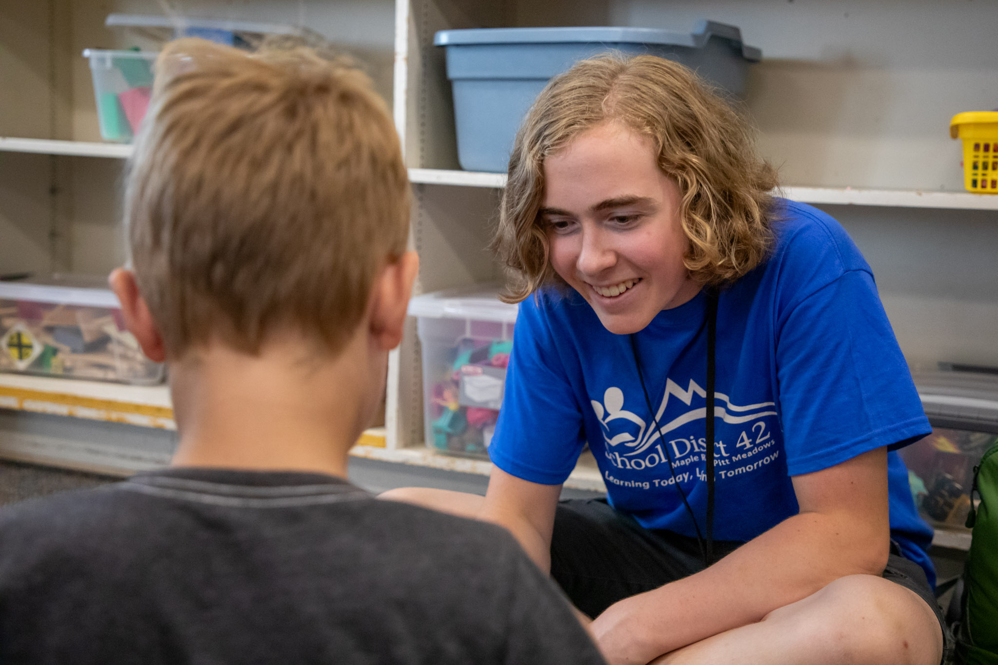 Summer learning volunteer Riley Carswell talks to a student.